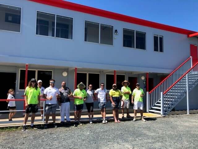 team lined up outside completed painting job