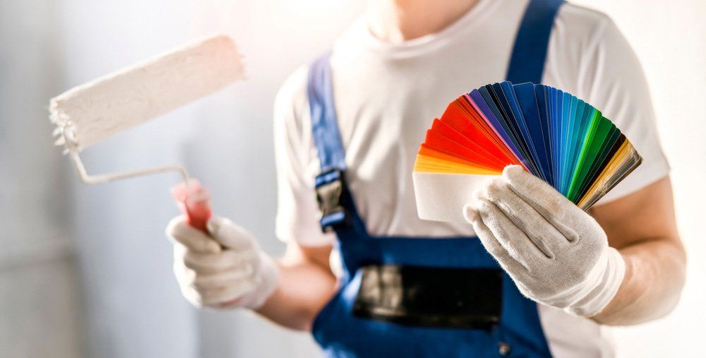 Painter Holding A Roller And Color Palette - Painting Services in North Mackay, QLD
