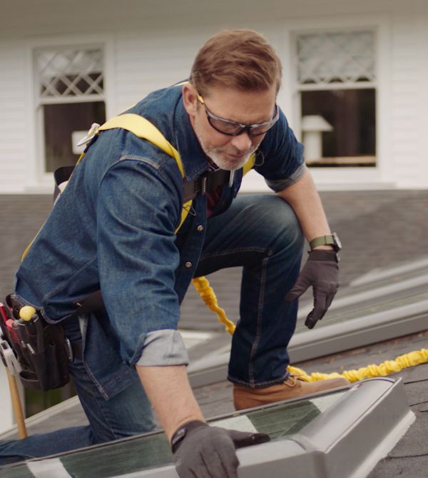 Two windows are being installed in a room under construction.
