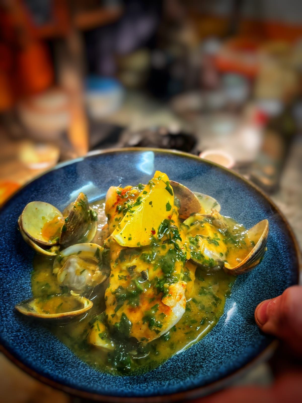 A person is holding a plate of food on a table.