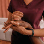 A woman is holding a man 's hand in her hands.