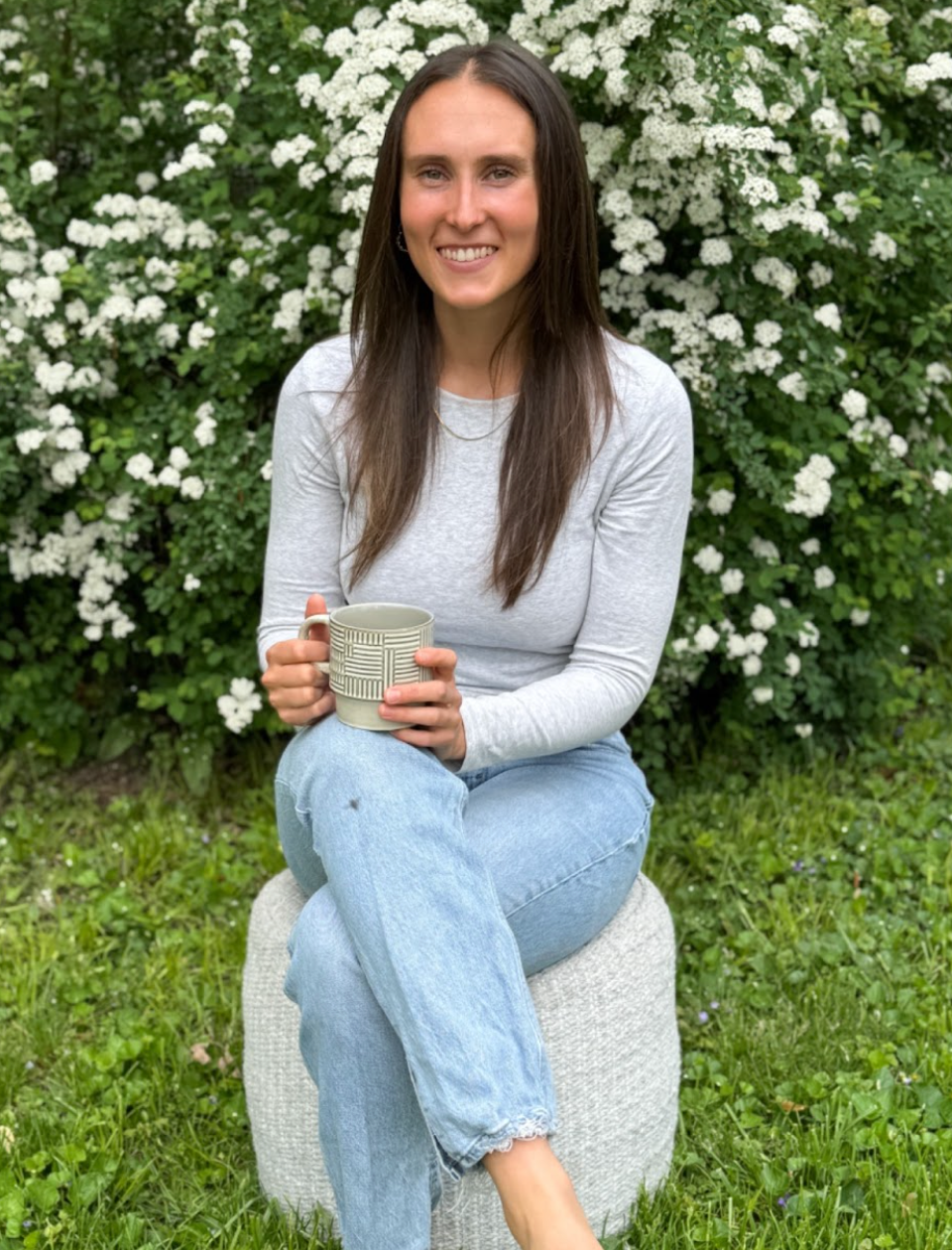 As a nutritionist, I make and eat delicious pizza with wholesome ingredients. Jourdan bites into a slice of pizza as she sits on a porch.