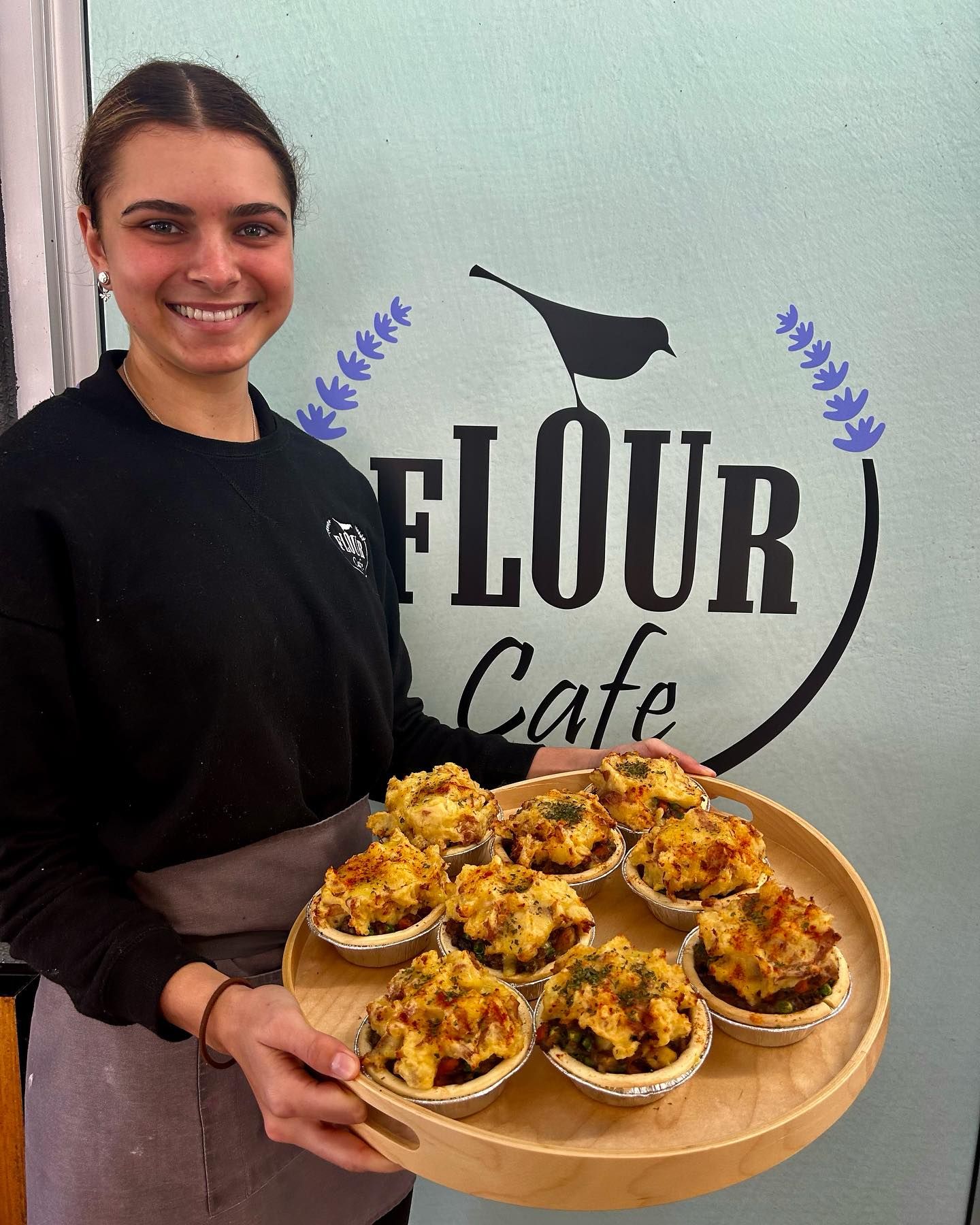 A Woman Holding Tray of Baked Goods — Flour in Yeppoon, QLD