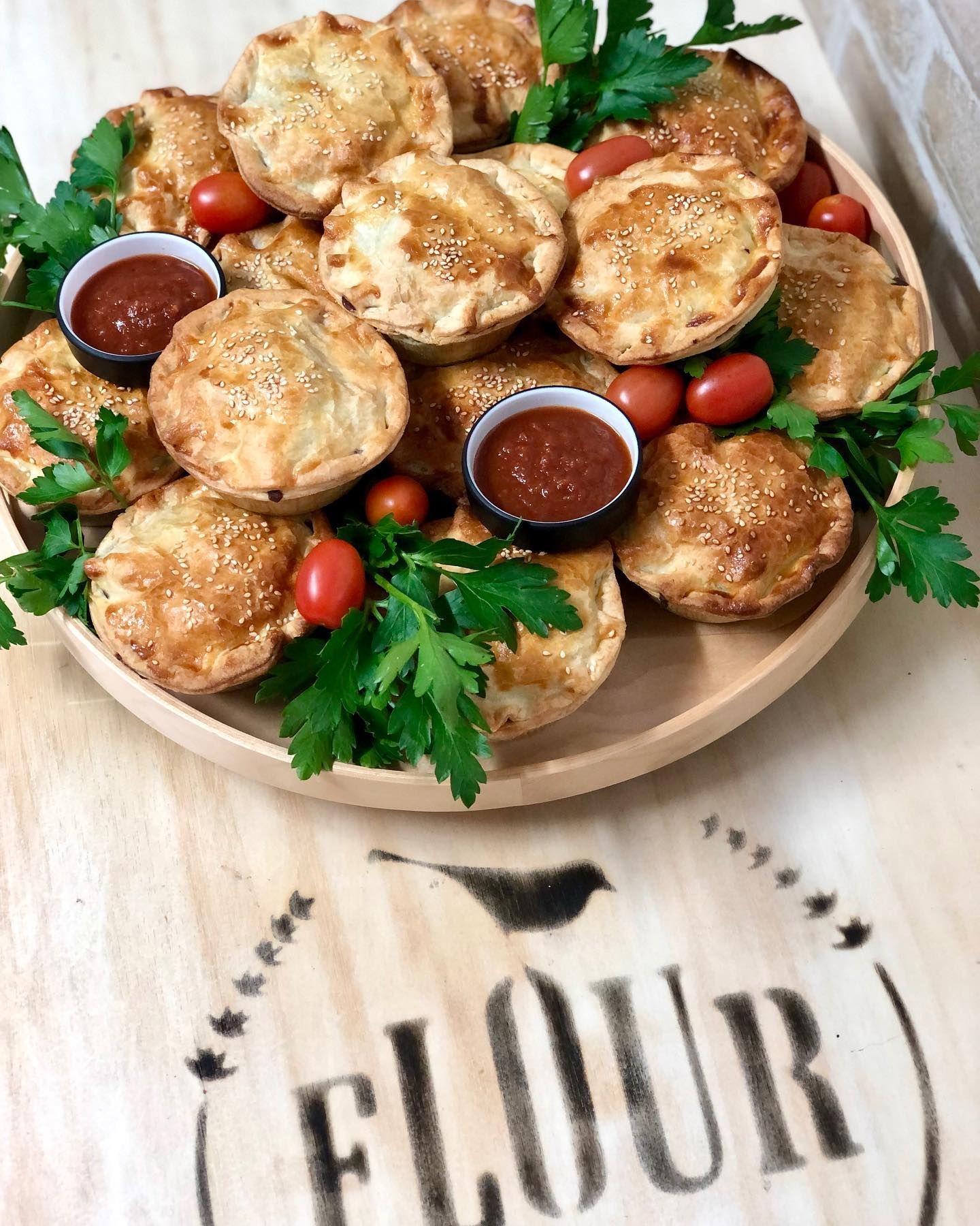 A Woman Holding Tray of Decorated Pastries — Flour in Yeppoon, QLD