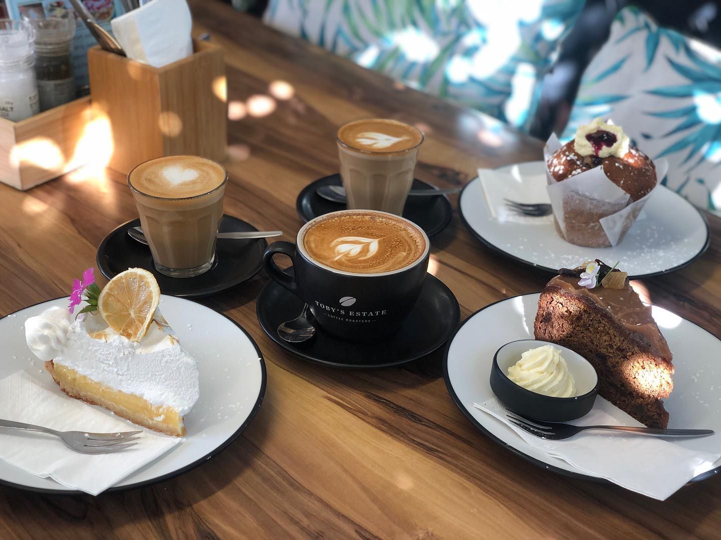A Latte With a Flower-shaped Design in the Foam, in a Grey Mug on a Wood Surface — Flour in Yeppoon, QLD
