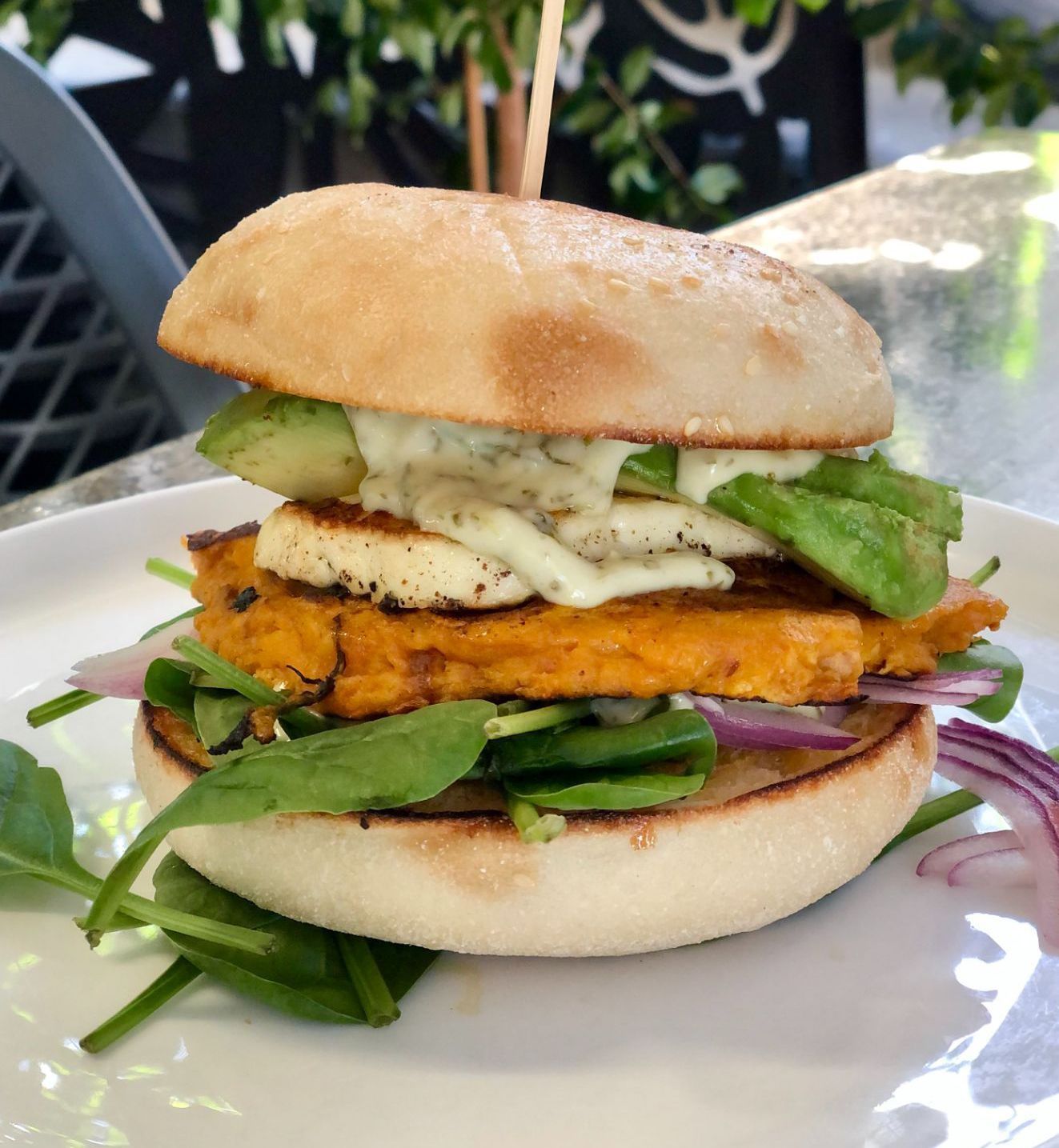 A Burger on a Plate With Sweet Potato Patty, Avocado, Halloumi, Greens, and Red Onion — Flour in Yeppoon, QLD