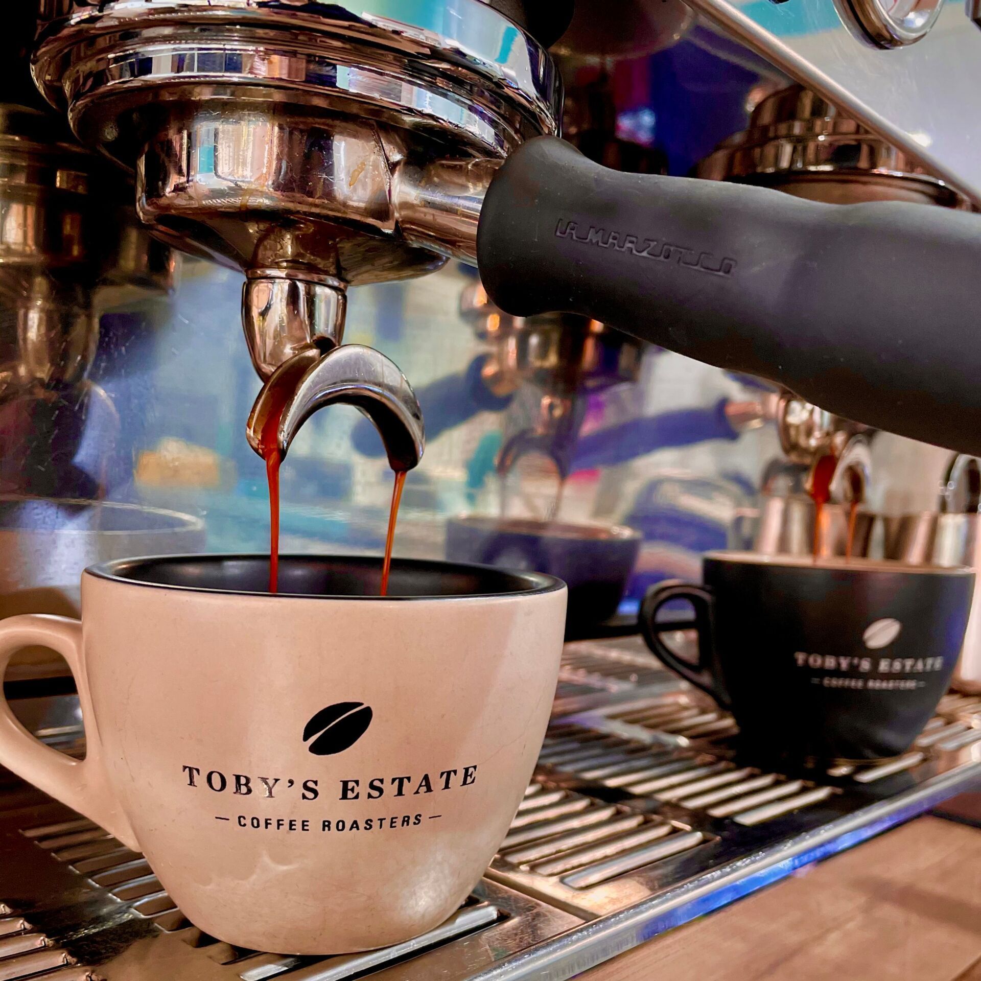 A Espresso Machine Pouring Coffee Into Two Toby's Estate Mugs on a Silver Tray — Flour in Yeppoon, QLD