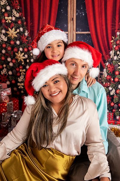 A family is posing for a picture in front of a christmas tree.