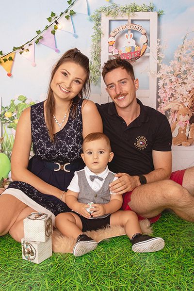 A family is posing for a picture while sitting on the grass.