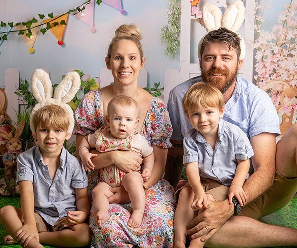 A family is posing for a picture while wearing bunny ears.