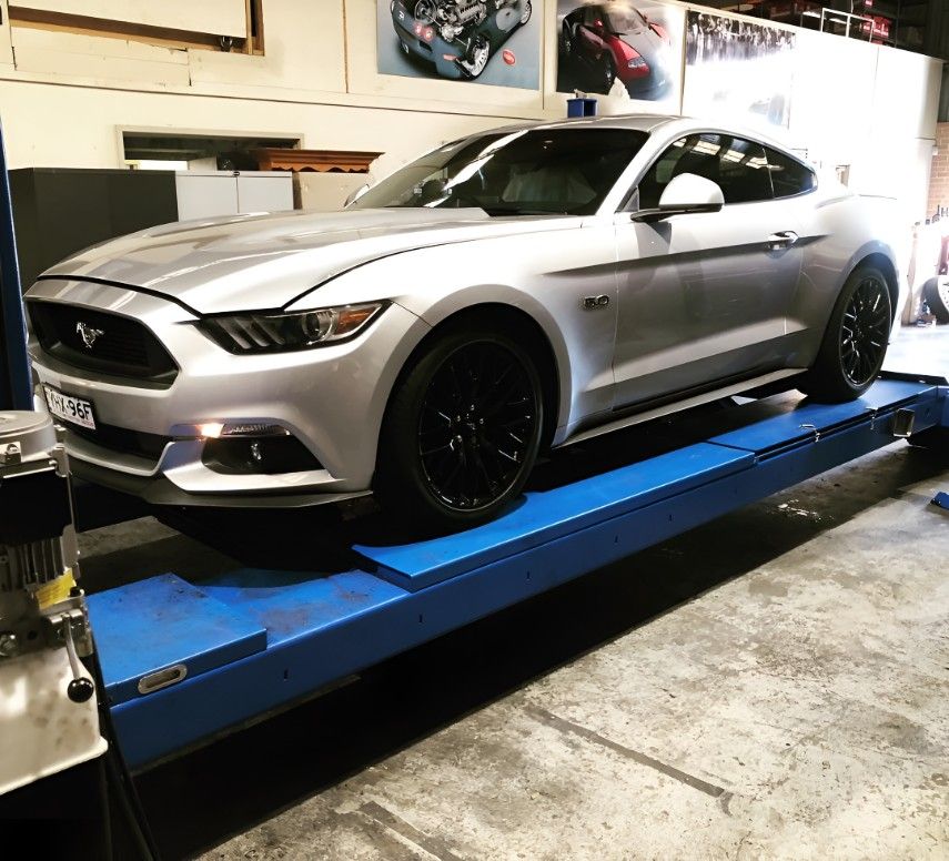 A Silver Mustang is on a Lift in a Garage — Autochange Mechanical Repairs & Tyres in Bellambi, NSW