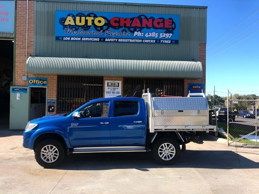 A Blue Truck is Parked in Front of a Building That Says Auto Change — Autochange Mechanical Repairs & Tyres in Bellambi, NSW