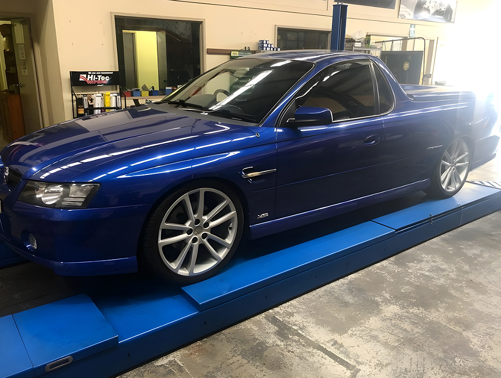 Blue Car on a Blue Lift Platform in a Garage — Autochange Mechanical Repairs & Tyres in Bellambi, NSW