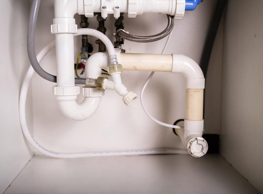 a close up of a sink plumbing system in a kitchen .