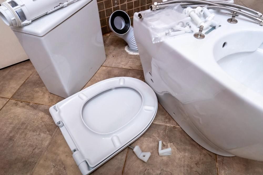 a toilet seat is laying on the floor next to a bathtub .