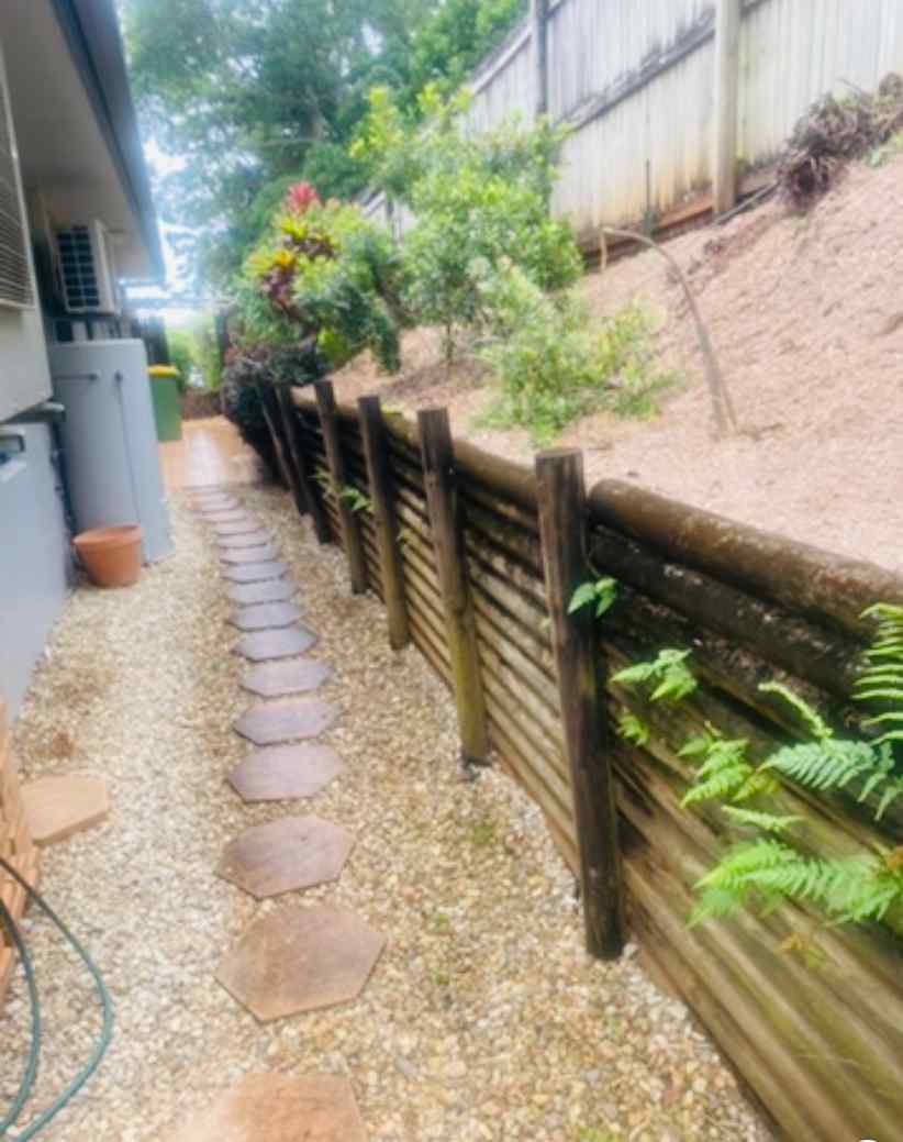 Pebbles with Stepping Stones & Wooden Retaining Wall — Trinity Landscape in Cairns, QLD