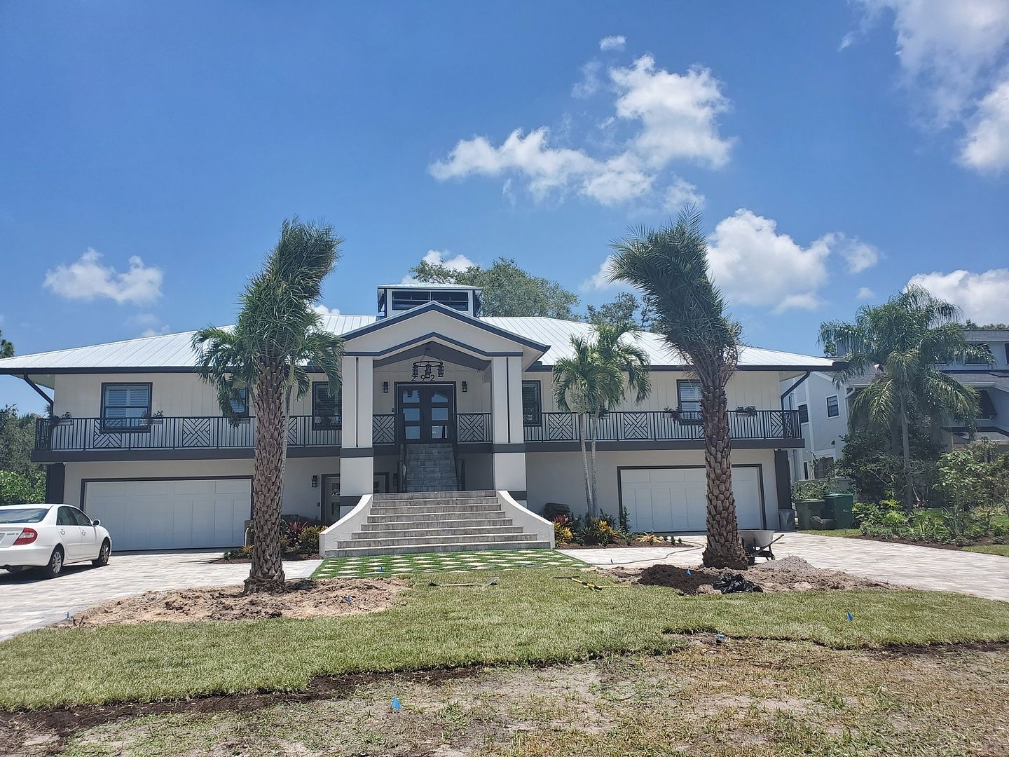 A large white house with a white car parked in front of it.