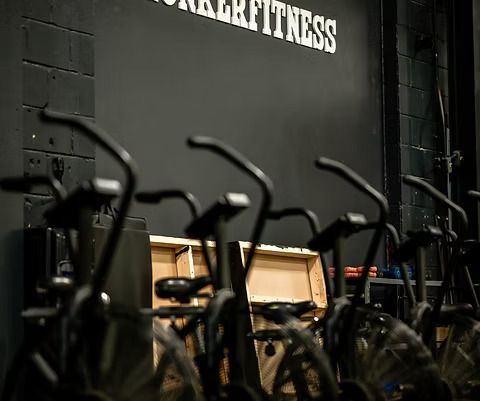 A row of exercise bikes are lined up in a gym.
