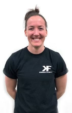 A woman wearing a black shirt with the letter f on it is smiling.