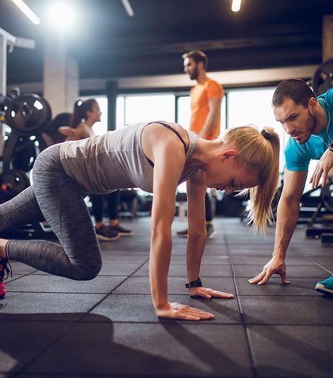 A group of people are doing push ups in a gym.