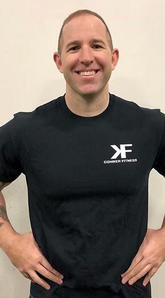 A man wearing a black shirt with the letter f on it
