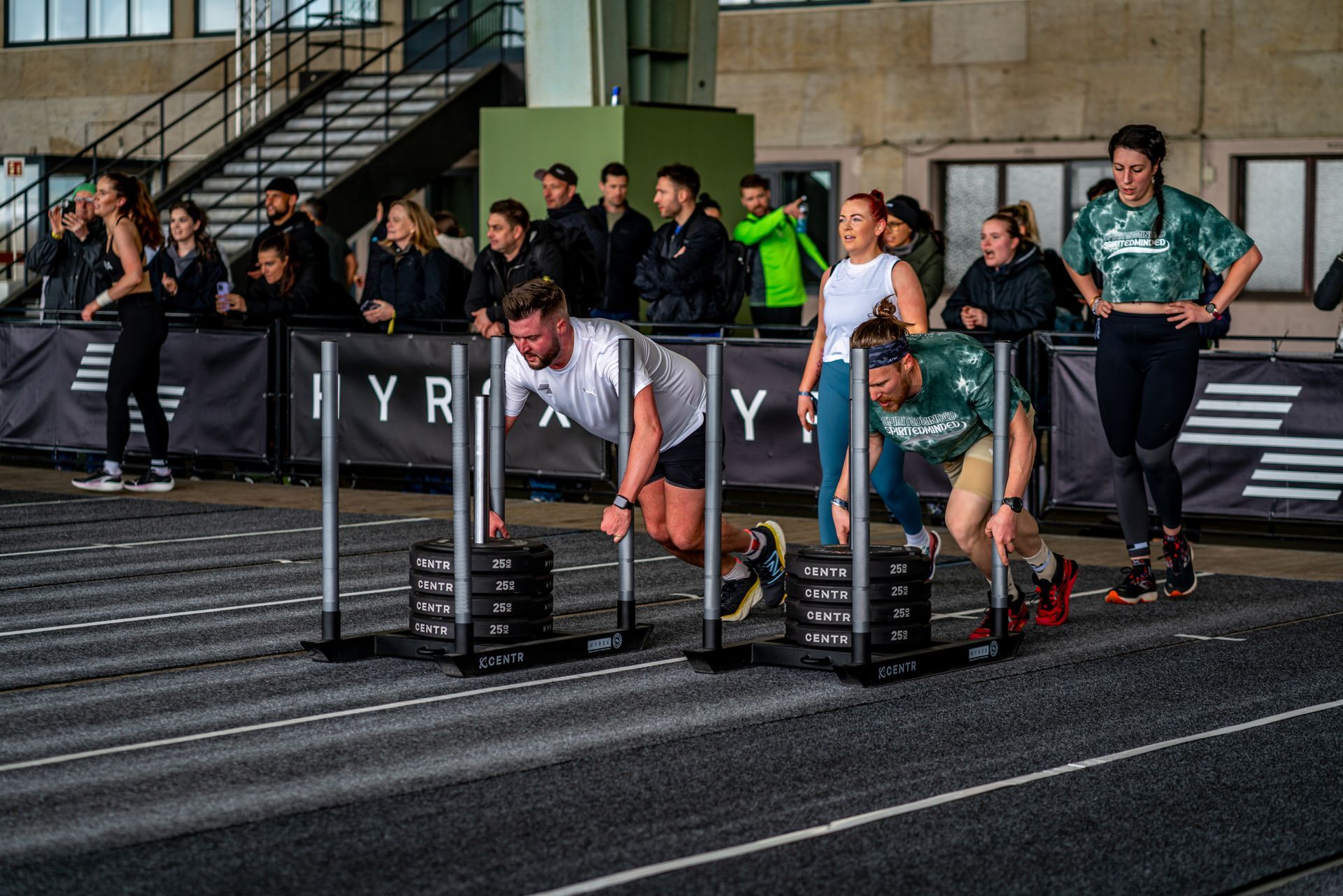 A woman in a green shirt is laughing with her mouth open