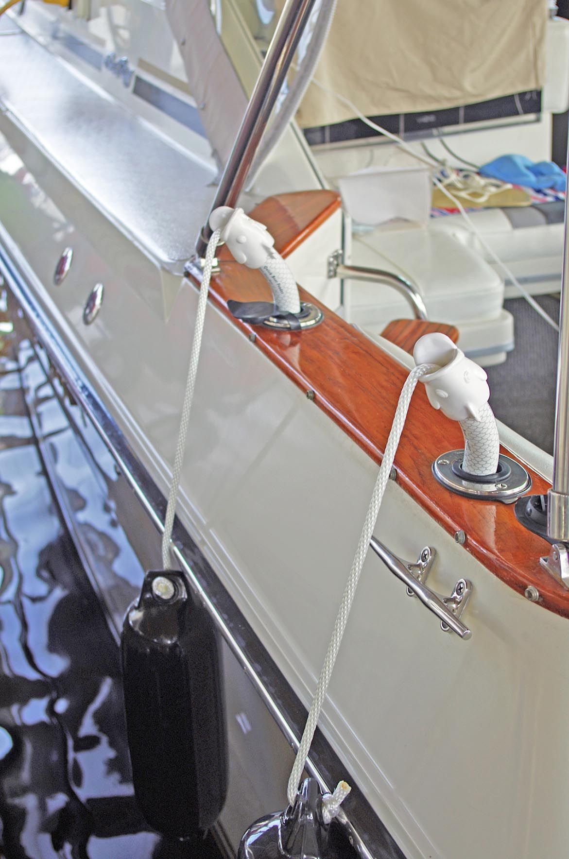 A close up of the side of a boat with ropes attached to it.