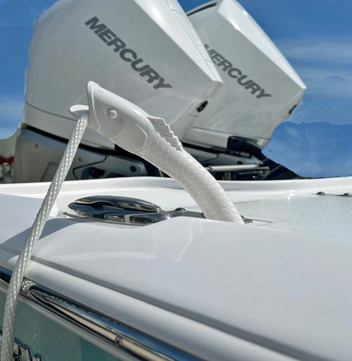 A white boat with two mercury engines on it