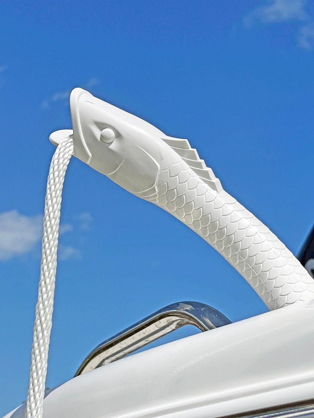 a white fish shaped rope holder on a boat