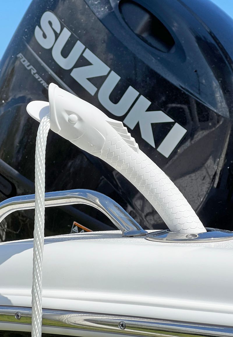 a suzuki four stroke outboard motor with a white handle