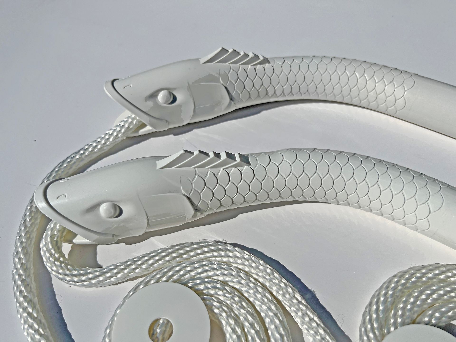 Two white fish shaped handles on a white rope