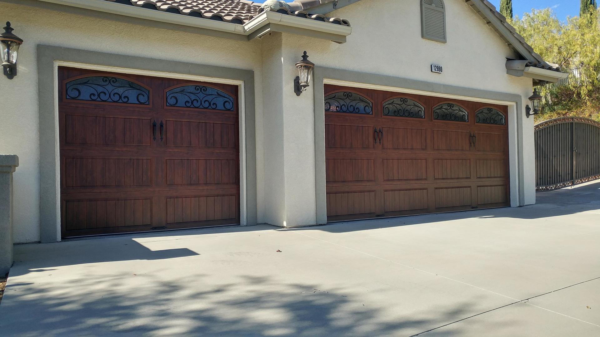 There are two garage doors on the side of a house.