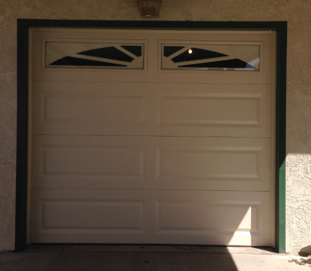 A white garage door with a green trim