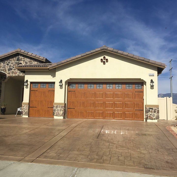 A house with two garage doors and a concrete driveway
