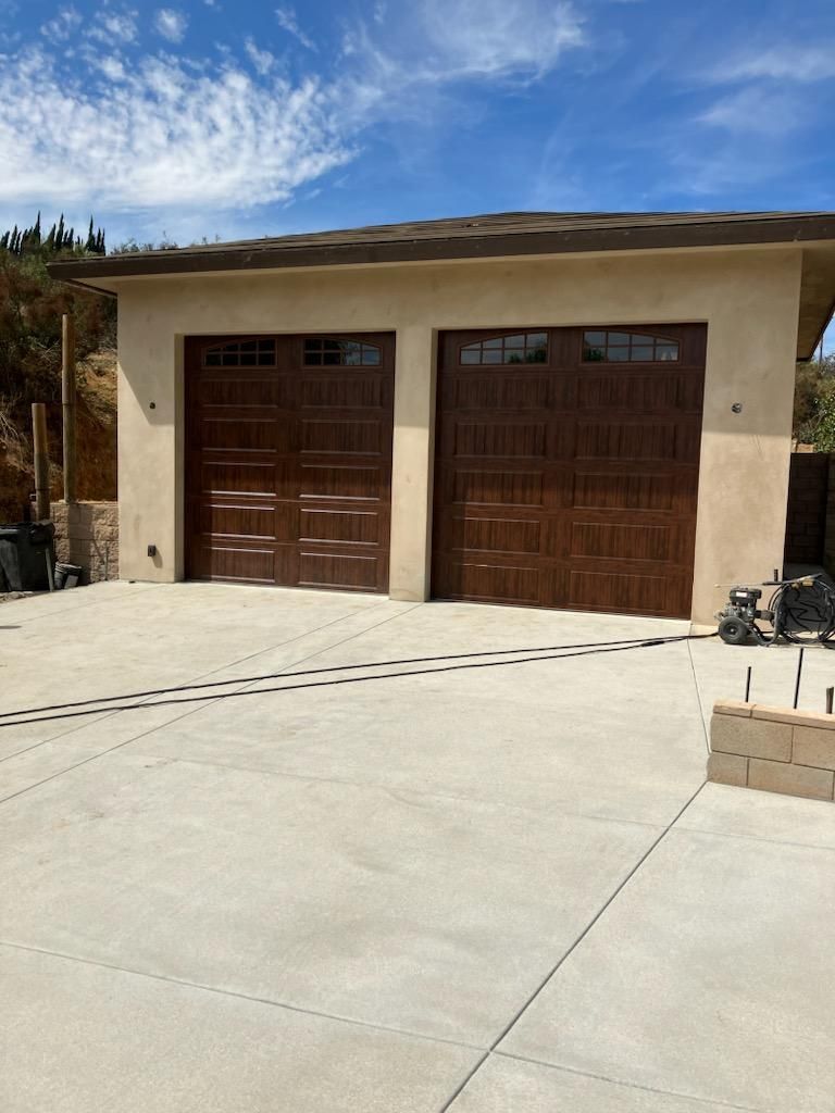 A Lloyd Copelan garage door with two brown garage doors and a concrete driveway in Yucaipa, CA