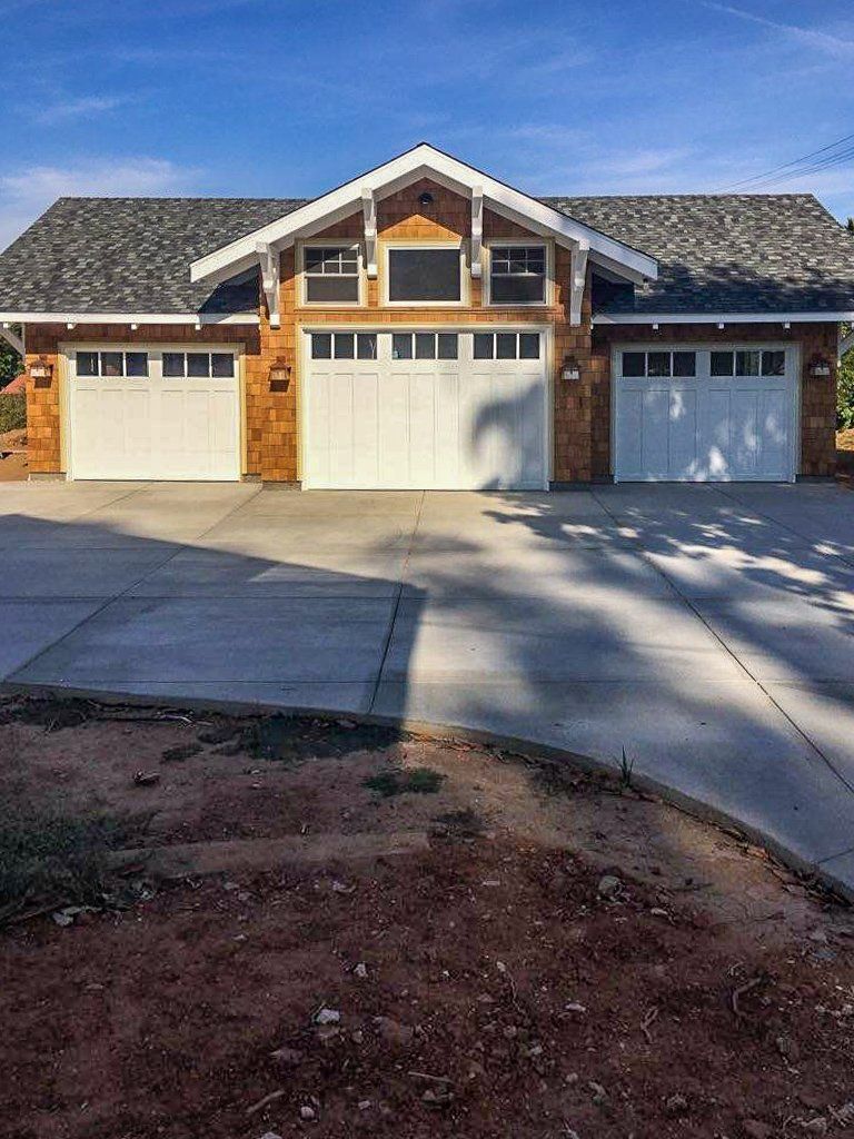 A house with three garage doors and a concrete driveway.