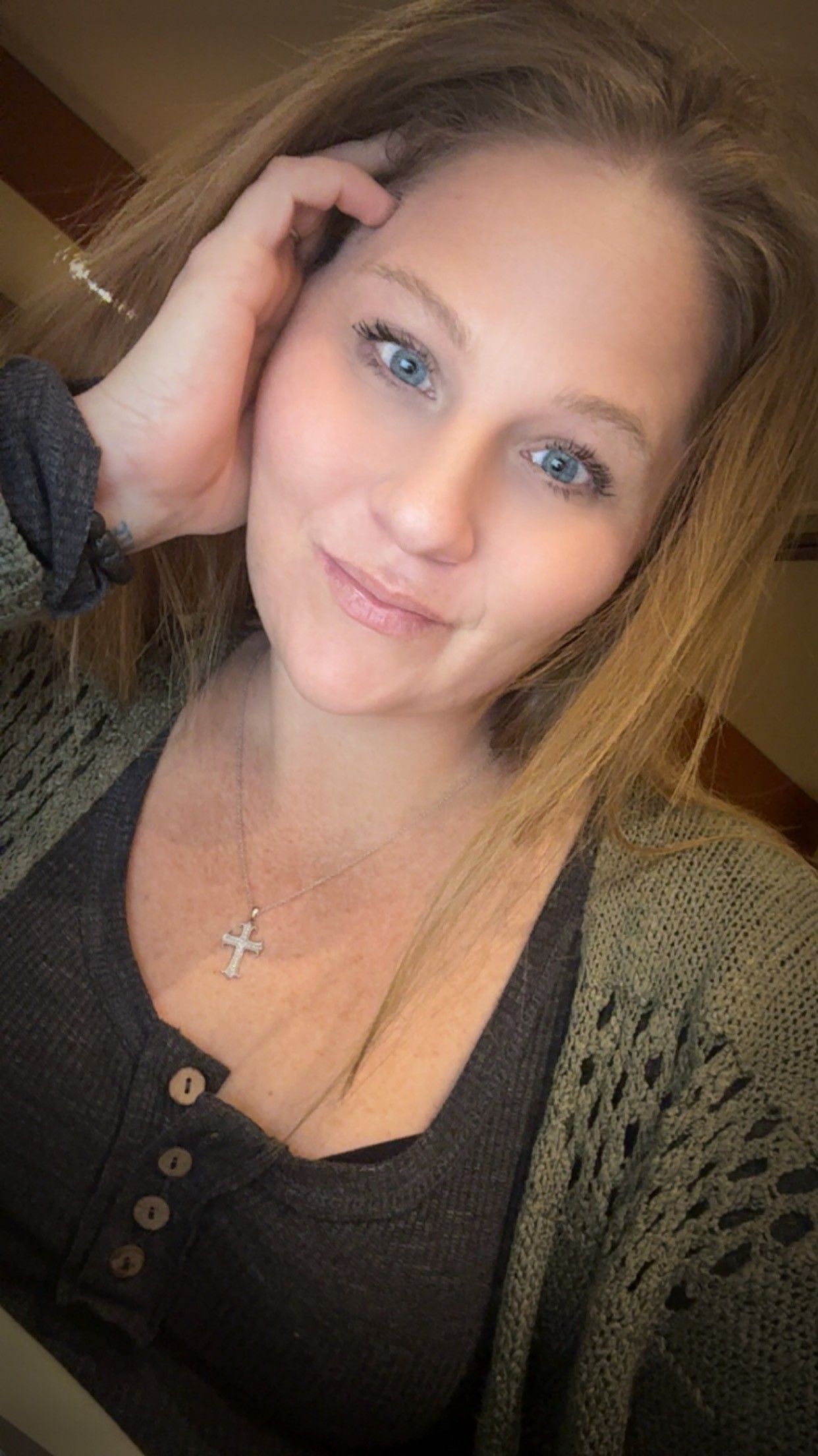 Smiling person with blue eyes resting head on hand