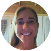 Smiling woman in a circular selfie, indoors with white cabinets and blinds in the background
