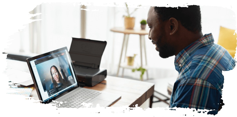 Man using a laptop for a video call in a bright home office