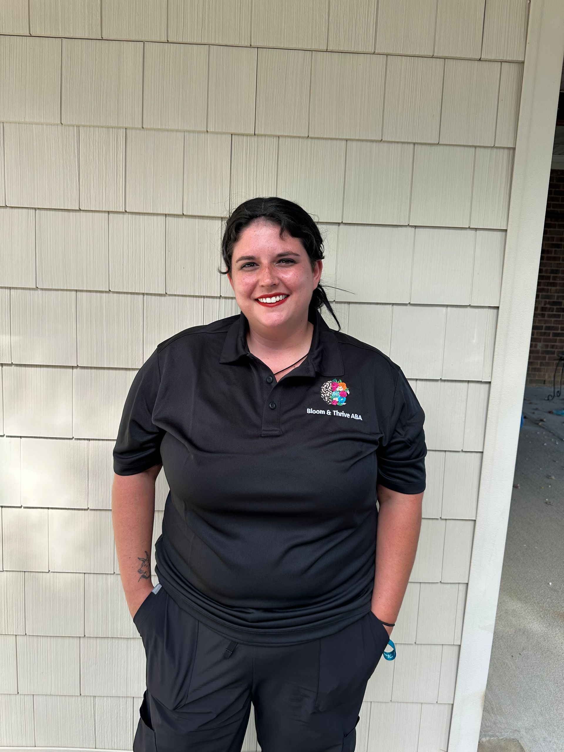 A young woman wearing a headband and a hoodie is smiling for the camera.