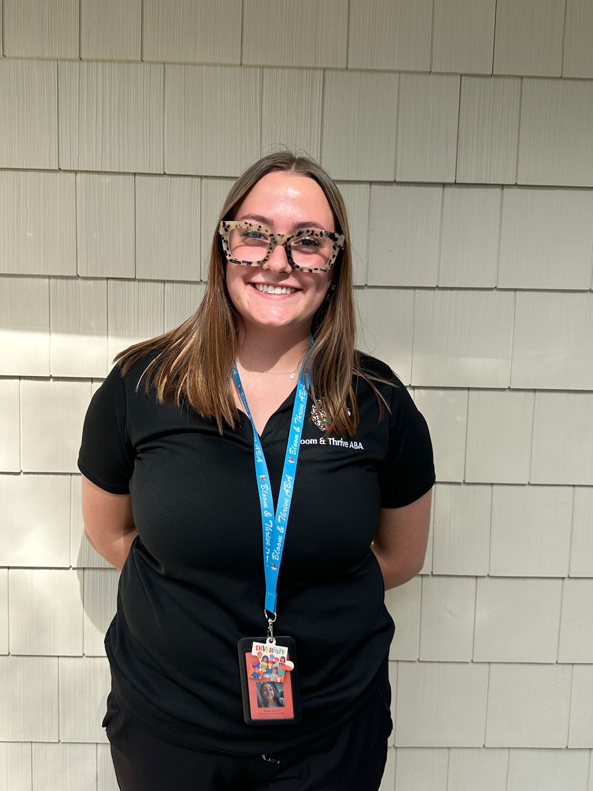 A woman with long brown hair is smiling for the camera