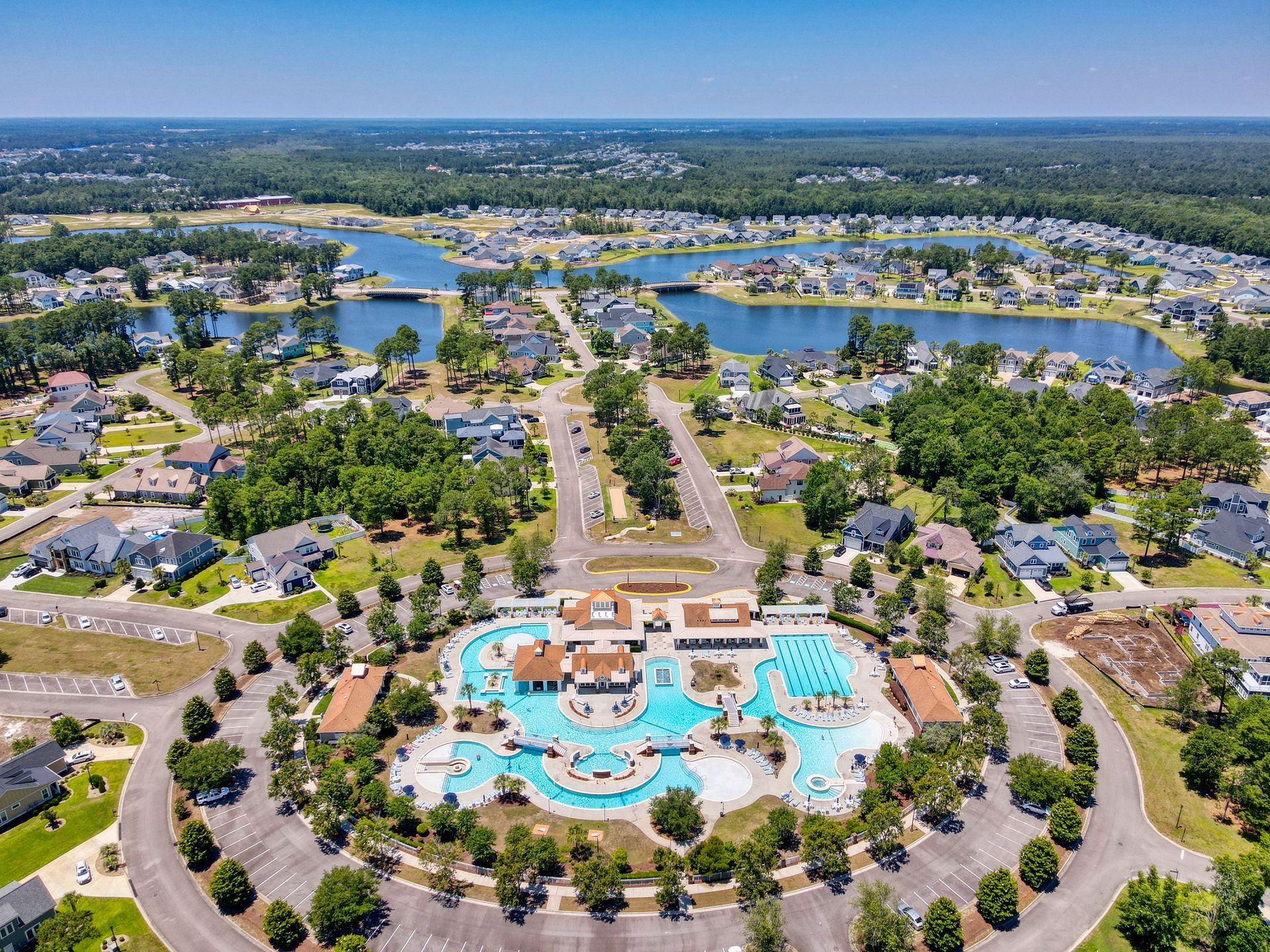 An aerial view of a residential area with a large swimming pool in the middle.