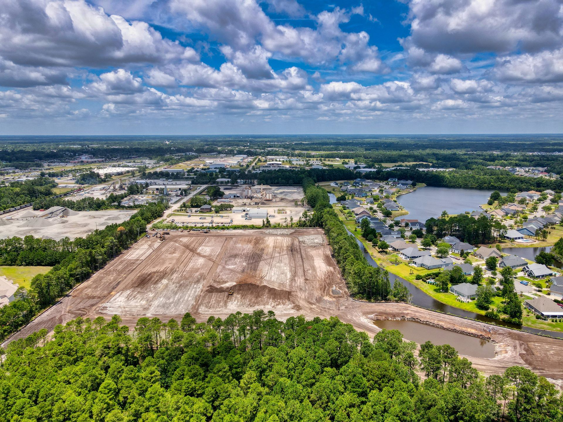 An aerial view of a residential area surrounded by trees and a lake.