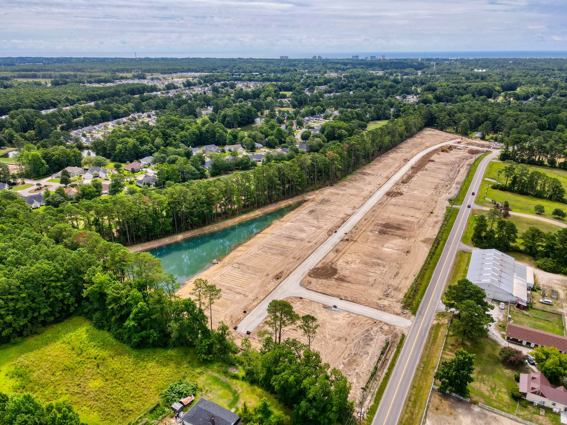 An aerial view of a residential area with a lake in the middle of it.