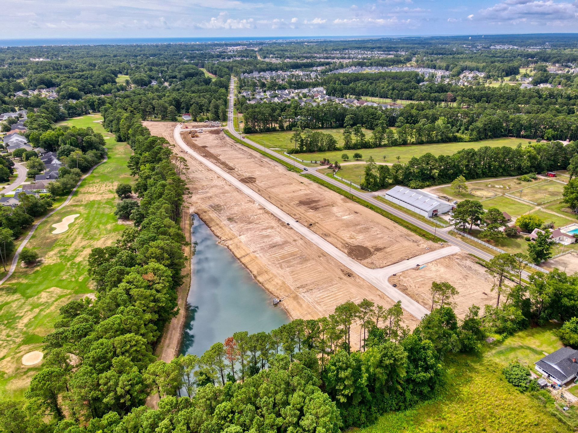 An aerial view of a residential development with a lake in the middle of it.