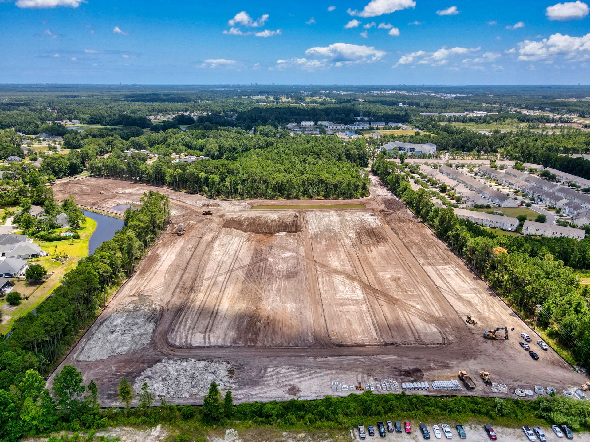 An aerial view of a large dirt field surrounded by trees.