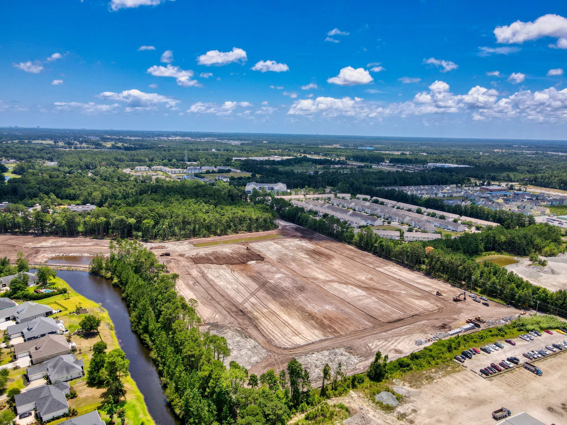 An aerial view of a construction site with a river running through it.