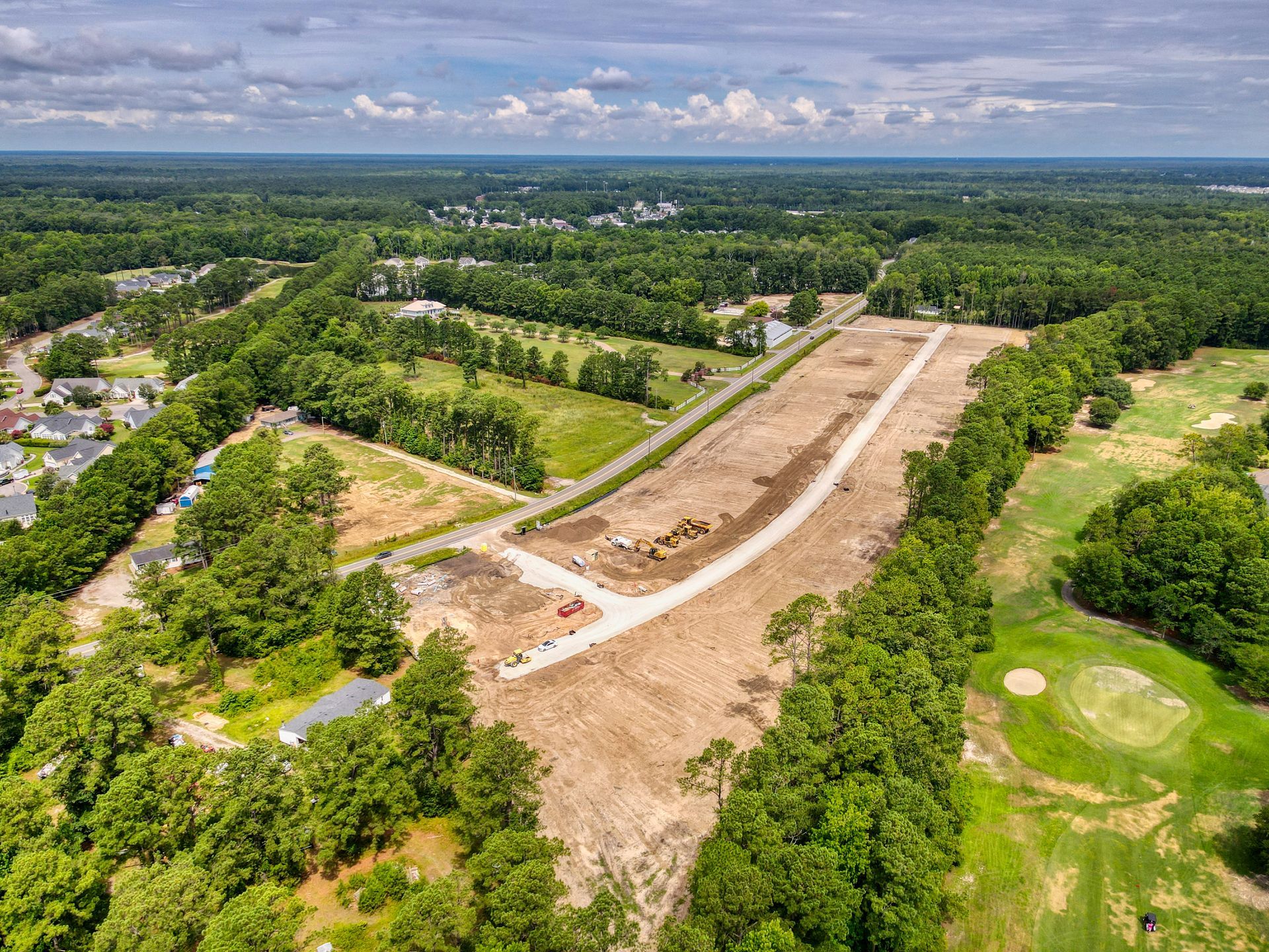 An aerial view of a residential area surrounded by trees and a golf course.