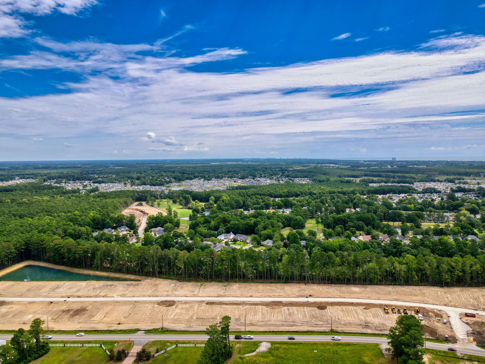 An aerial view of a residential area surrounded by trees and a lake.