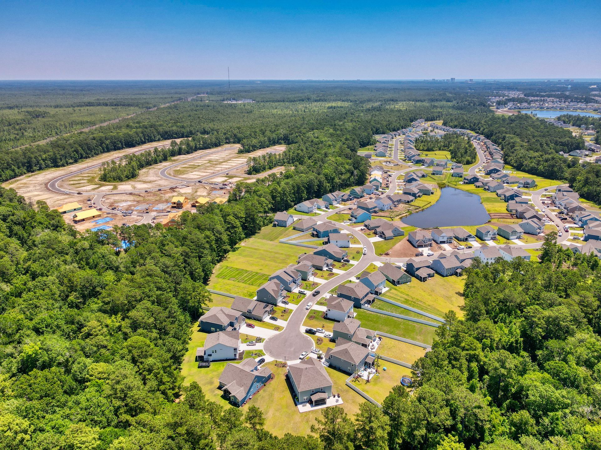 An aerial view of a residential area surrounded by trees and a lake.